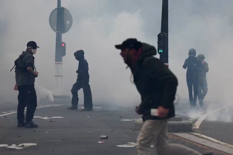 Los manifestantes caminan en medio de gases lacrimógenos durante la tradicional marcha sindical del día de Mayo en París, Francia, el 1 de mayo de 2024.