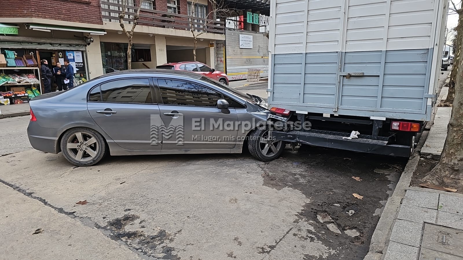 Choque entre un auto y un patrullero: terminó debajo de un camión